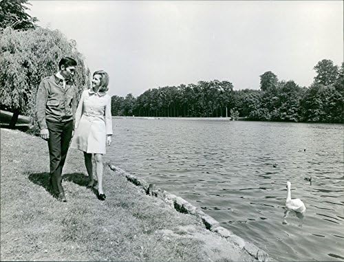 Vintage fotografija Eddyja Merckxa kako šeta sa suprugom na obali jezera.